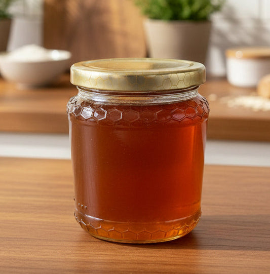 Jar of honey with a gold lid on a wooden surface