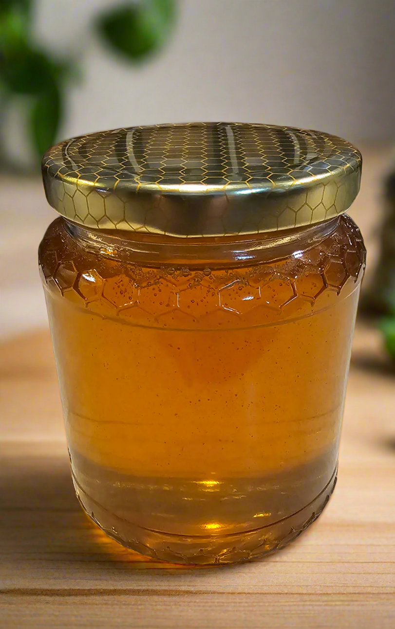 Jar of honey with a gold lid on a countertop